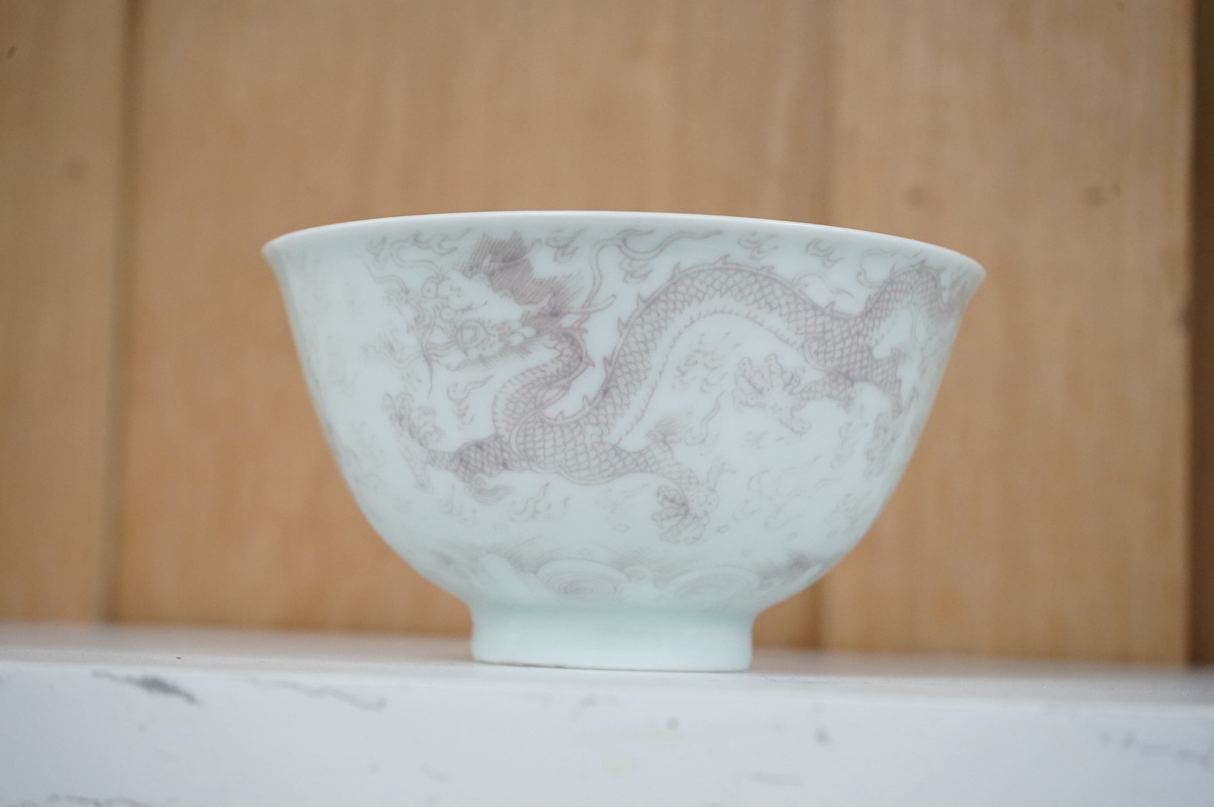A Chinese underglaze copper red ‘dragon' bowl, Kangxi mark to base but later, 11cm diameter. Condition - good